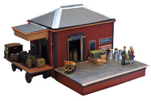 Load image into Gallery viewer, Rail Model Rhoystellen Station Goods Shed, 4 mm scale—fully assembled and detailed diorama featuring a red-brick GWR parcels office with pitched roof, loading canopy, signage, milk churns, crates, sacks, and miniature figures on a raised platform alongside a delivery cart.