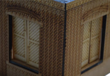Load image into Gallery viewer, Rail Model Rhoystellen Station Goods Shed, 4 mm scale—close-up of the assembled laser-cut MDF brick structure, focusing on the corner junction with detailed brick courses, arched lintels, and diagonally-planked sliding goods doors.