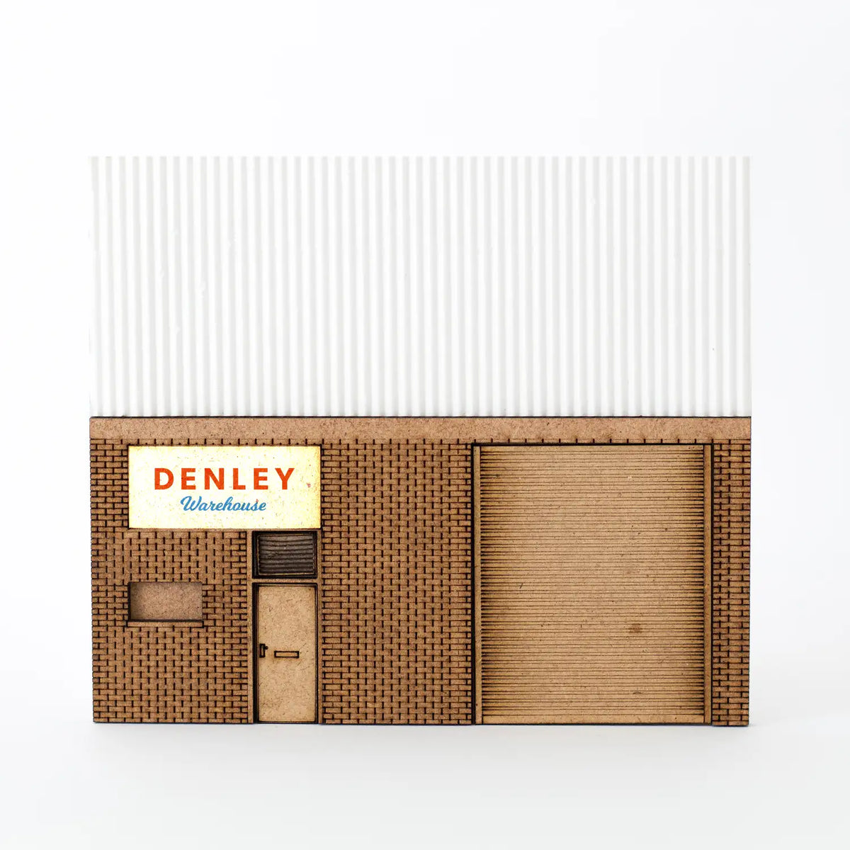 Rail Model Light Industrial Unit Relief, 4 mm scale—front-facing view of a detailed warehouse facade featuring laser-engraved brickwork, personnel door, roller shutter door, corrugated cladding, and a ‘DENLEY Warehouse’ sign above the entrance.