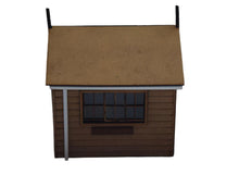 Load image into Gallery viewer, A laser cut and engraved model of a signal box with a brown roof, gray walls, a window with black film, and a gutter and downpipe.