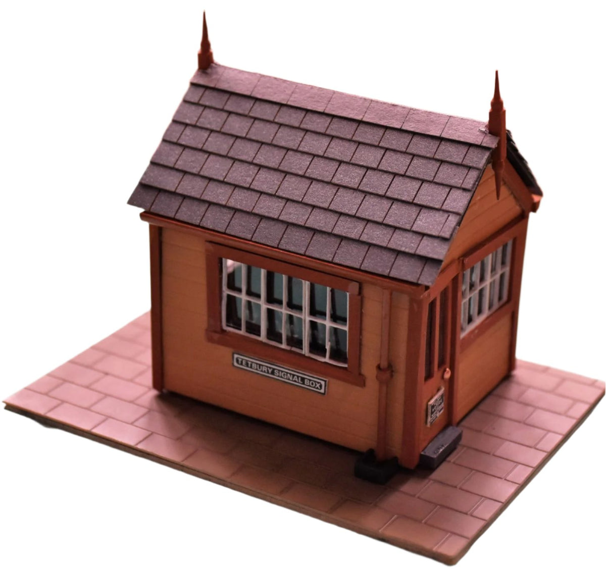 A model building with roof tiles made from grey slate card, depicting a small house or shed typically used in model train setups.