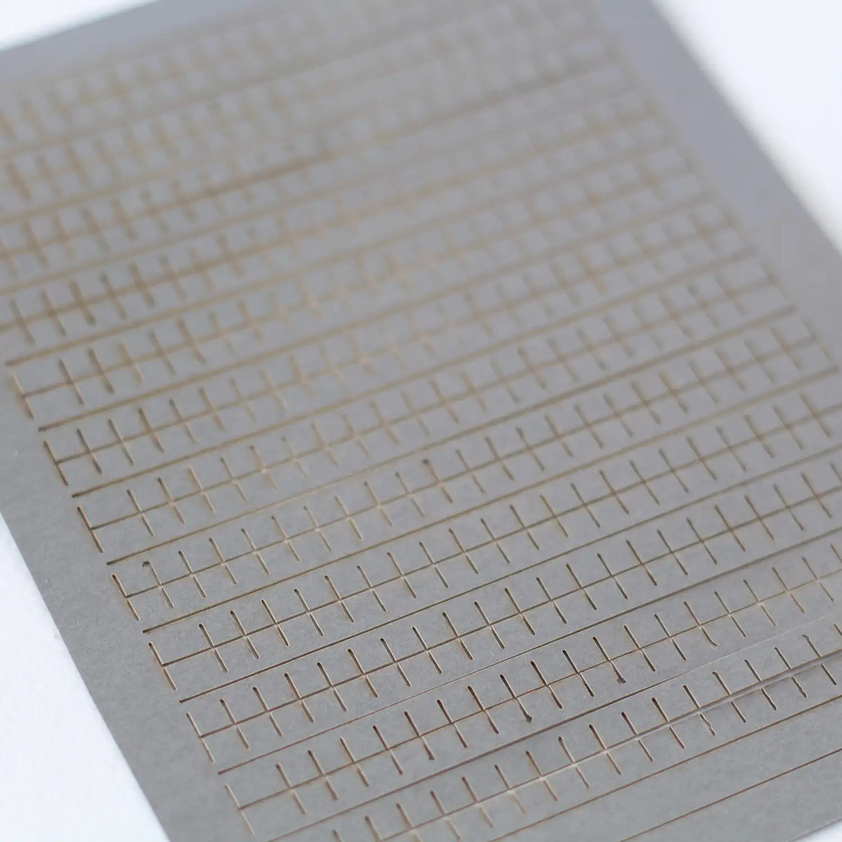 Rail Model Terraced House 4 mm scale—close-up of a laser-cut grey card roof-tile sheet showing precise parallel rows of rectangular slates supplied with the kit.
