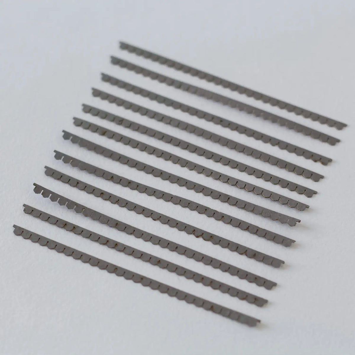 Rail Model Terraced House 4 mm scale—array of individual laser-cut grey card roof-tile strips with scalloped lower edges, neatly laid out on a white background.