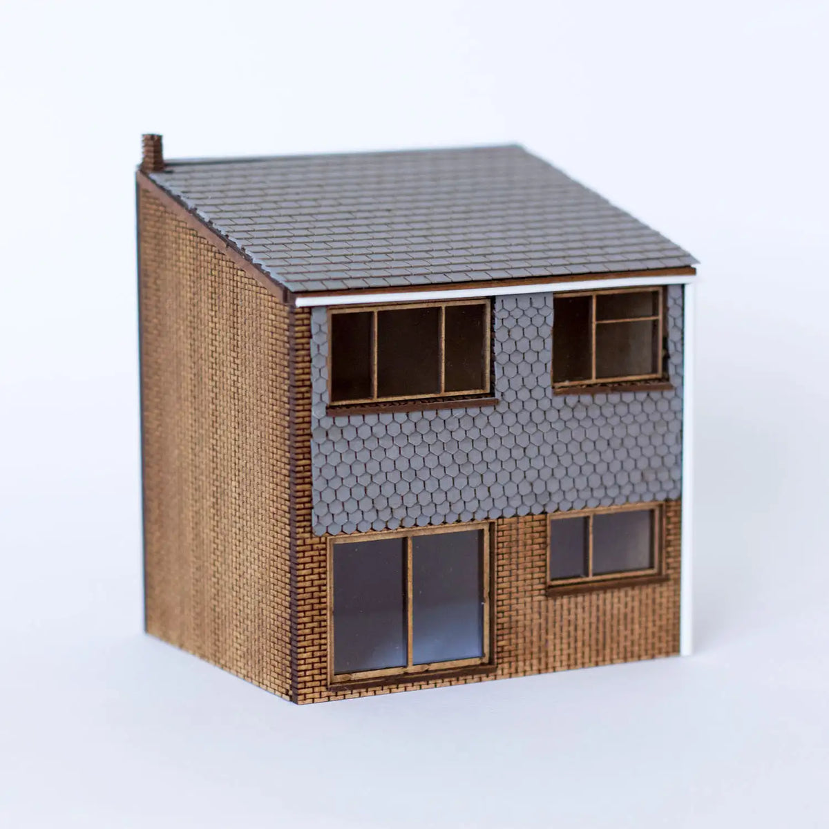 Rail Model Terraced House 4 mm scale—assembled 1960s two-storey terrace with brown brick lower walls, grey hexagonal-tile cladding above, shallow tiled roof, sliding patio door, and three framed windows, displayed on a white background.