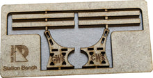 Load image into Gallery viewer, A model of a station platform bench made from MDF, painted and placed on a layout with a brick wall in the background.