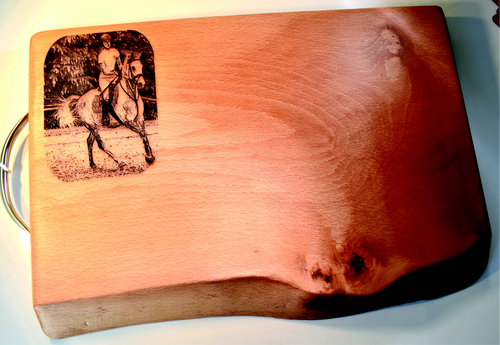 Wooden cutting board with engraved image of a person on horseback