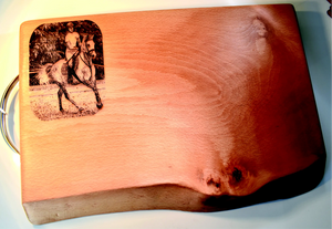 Wooden cutting board with engraved image of a person on horseback