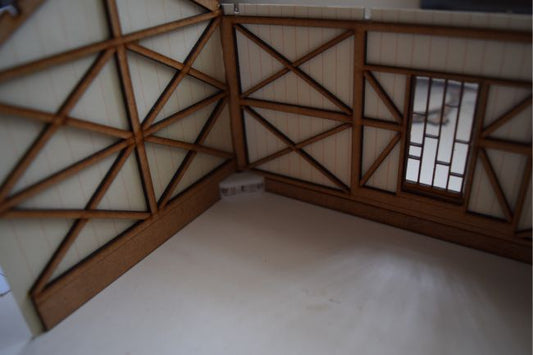 A photo showing a model of a timber built carriage shed, featuring a tiled roof and wooden truss details.