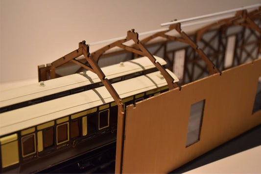 A model of a timber built carriage shed, featuring laser cut and etched details, with a vented tiled roof.