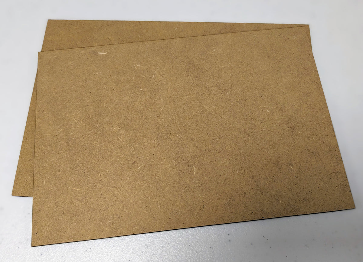 Two sheets of brown 1mm thick MDF small sheet box, positioned one on top of the other on a plain surface.
